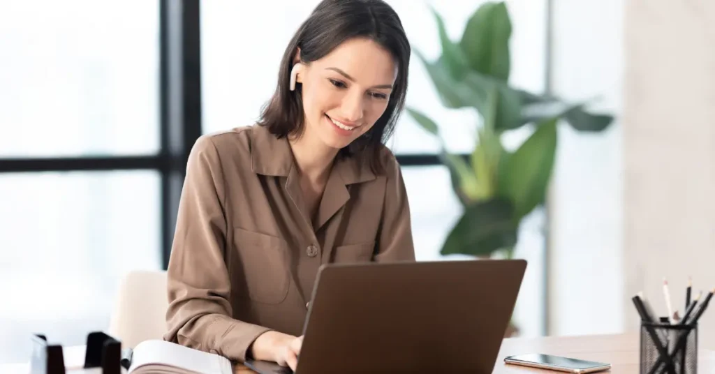 mujer trabajando en la pc creando un producto en canva